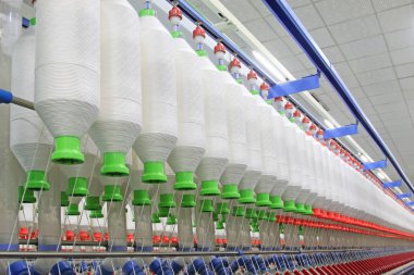 Fabrikada dönen makine parçaları ve pamuk ipliği, yakın çekim