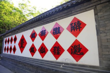 Beyaz duvarda kırmızı kağıt siyah kelimeler, fotoğrafa yakın çekim.