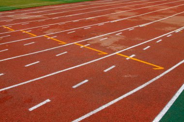 bir ortaokulun spor sahasında ıslak kırmızı plastik pist