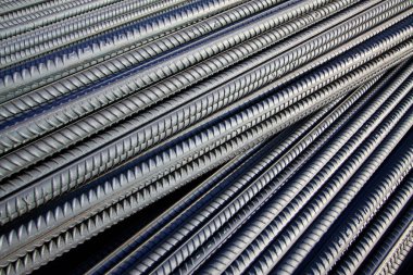 Deforme olmuş çelik çubuk üst üste yığılmış, fotoğrafa yakın.