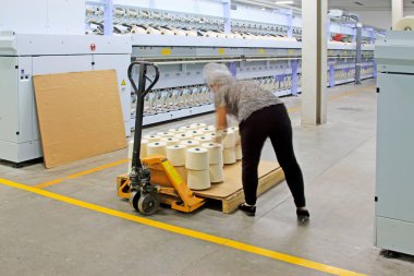 Dönen makine parçaları ve fabrikadaki işçiler, yakın çekim