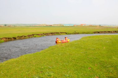 TULIGEN GRASSLAND - 20 Temmuz 2014: Ziyaretçiler Tuligen Nehri 'nde 20 Temmuz 2014 tarihinde şişme sandal sürüklenmesi, Xilin gol ligi, Moğolistan özerk bölgesi, Çin.