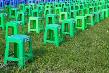 Parktaki çalılıklarda plastik tabureler