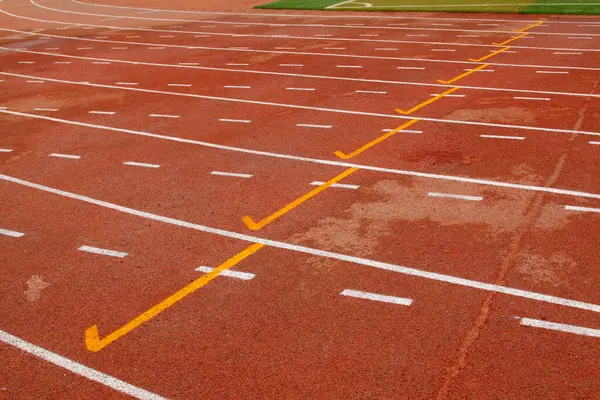 bir ortaokulun spor sahasında ıslak kırmızı plastik pist