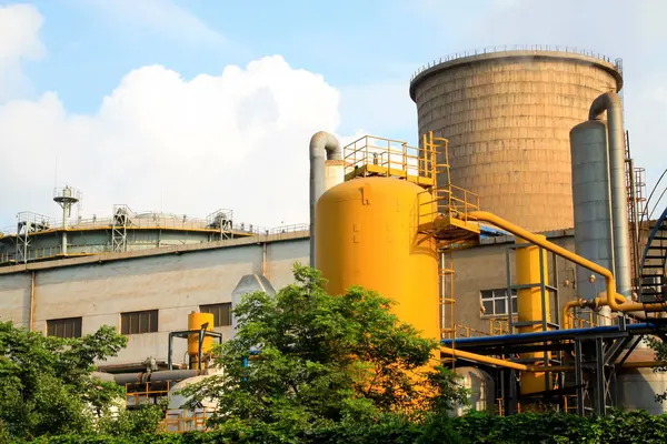 Sarı metal kutular ve soğutma kulesi fabrikada.