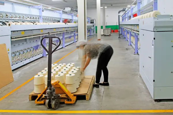 Dönen makine parçaları ve fabrikadaki işçiler, yakın çekim