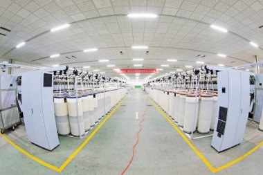 LUANNAN COUNTY - 20 Aralık 2013 'te, Luannan Eyaleti, Hebei Eyaleti, Çin' de, ZeAo Spin LTD 'deki bir üretim atölyesinde dönen makineler ve pamuk taranmıştır..