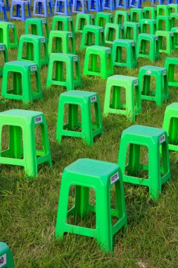 Parktaki çalılıklarda plastik tabureler