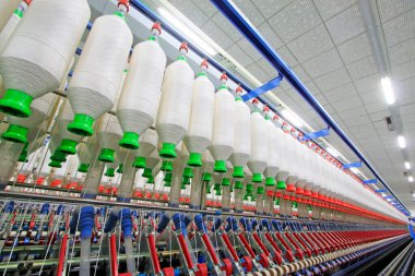 Fabrikada dönen makine parçaları ve pamuk ipliği, yakın çekim