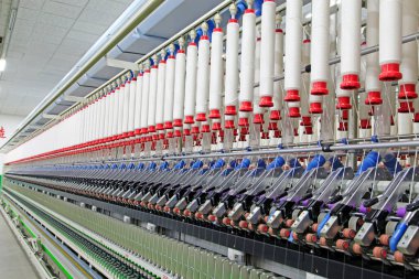 Fabrikada dönen makine parçaları ve pamuk ipliği, yakın çekim