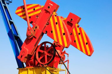 Petrol makinelerinin parçaları mavi gökyüzünün altındaki blokları dengeliyor