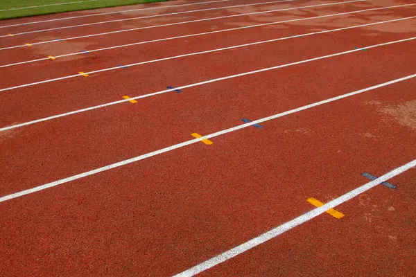 bir ortaokulun spor sahasında ıslak kırmızı plastik pist