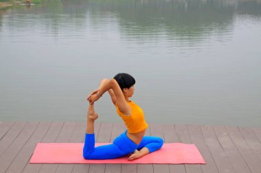 Luannan County - 25 Temmuz 2015 'te parkta yoga egzersizi yapan bir kadın, Luannan County, Hebei, Chin