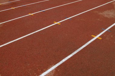 bir ortaokulun spor sahasında ıslak kırmızı plastik pist