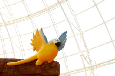 Parktaki sarı kuş heykeli, fotoğrafa yakın çekim.