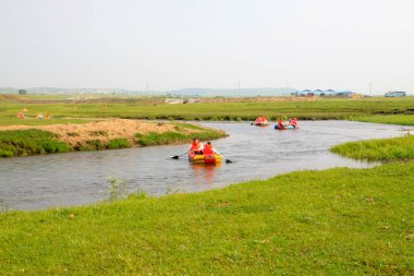 TULIGEN GRASSLAND - 20 Temmuz 2014: Ziyaretçiler Tuligen Nehri 'nde 20 Temmuz 2014 tarihinde şişme sandal sürüklenmesi, Xilin gol ligi, Moğolistan özerk bölgesi, Çin.