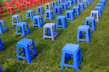 Parktaki çalılıklarda plastik tabureler