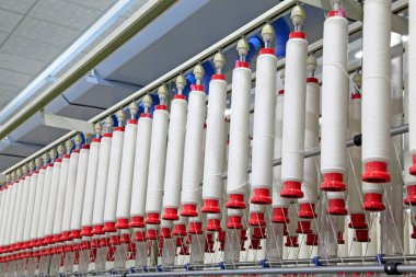Fabrikada dönen makine parçaları ve pamuk ipliği, yakın çekim