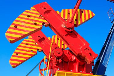 Petrol makinelerinin parçaları mavi gökyüzünün altındaki blokları dengeliyor