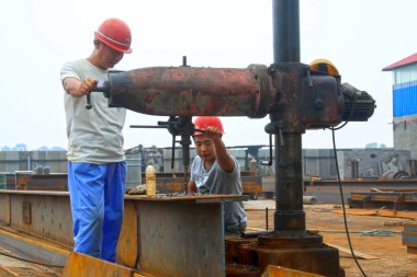 TANGSHAN - 21 Temmuz 2014 'te, Tangshan, Hebei Eyaleti, Chin' de bir fabrikada çelik levhayı yumruklayan işçiler