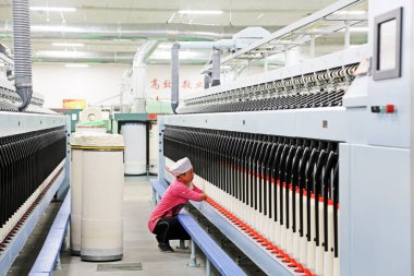 LUANNAN COUNTY - 20 Aralık 2013 'te, Luannan Eyaleti, Hebei Eyaleti, Çin' deki ZeAo Spin LTD 'deki bir üretim atölyesinde mekanik ekipmanlar çalışıyordu..