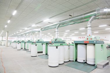 LUANNAN COUNTY - 20 Aralık 2013 'te, Luannan Eyaleti, Hebei Eyaleti, Çin' deki ZeAo Spin LTD 'deki bir üretim atölyesinde mekanik ekipmanlar çalışıyordu..