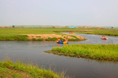 TULIGEN GRASSLAND - 20 Temmuz 2014: Ziyaretçiler Tuligen Nehri 'nde 20 Temmuz 2014 tarihinde şişme sandal sürüklenmesi, Xilin gol ligi, Moğolistan özerk bölgesi, Çin.