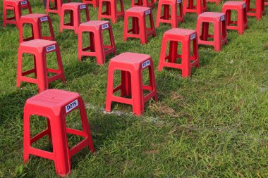 Parktaki çalılıklarda plastik tabureler