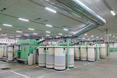 Fabrikada dönen makine parçaları ve beyaz plastik kovalar, yakın çekim