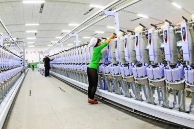 LUANNAN COUNTY - 20 Aralık 2013 'te, Luannan Eyaleti, Hebei Eyaleti, Çin' deki ZeAo Spin LTD 'de bir üretim atölyesinde dönen makine ve ekipman.