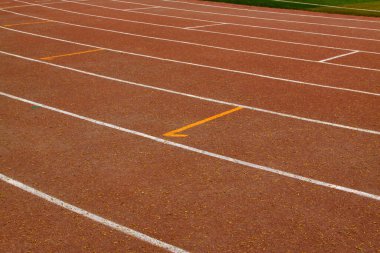 bir ortaokulun spor sahasında ıslak kırmızı plastik pist