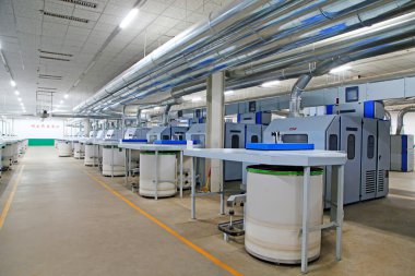 Fabrikada dönen makine parçaları ve beyaz plastik kovalar, yakın çekim