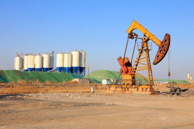 Pompalama ünitesi ve bituminous beton karıştırma istasyonu mavi gökyüzünün altında yağlı fiilde