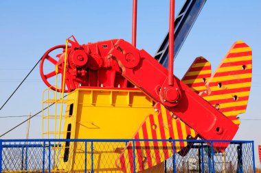 Petrol makinelerinin parçaları mavi gökyüzünün altındaki blokları dengeliyor