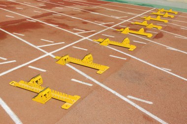 Ortaokuldaki bir spor sahasında kırmızı plastik bir pistte