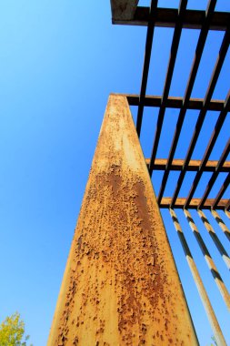 Oksitlenme, paslanma, mavi gökyüzü arka planında çelik kirişler, fotoğrafa yakın çekim.