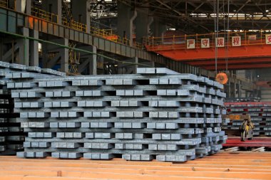 Çelik külçeler bir atölyede bir araya toplanmış, fotoğrafın yakın çekimi.