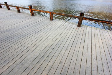 Parkta ahşap zemin ve korkuluklar, fotoğrafa yakın çekim.