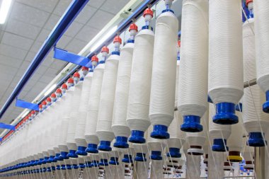 Fabrikada dönen makine parçaları ve pamuk ipliği, yakın çekim