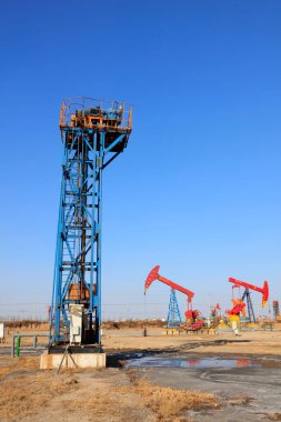 Petrol sahasında mavi gökyüzünün altında kule tipi pompalama ünitesi