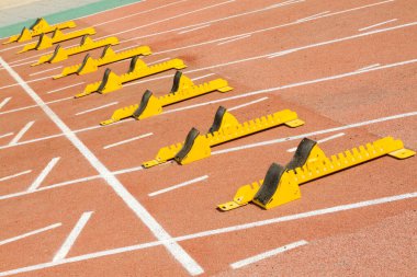 Ortaokuldaki bir spor sahasında kırmızı plastik bir pistte