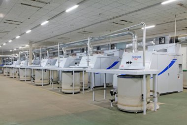 Fabrikada dönen makine parçaları ve beyaz plastik kovalar, yakın çekim