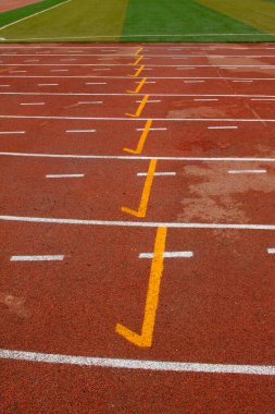 bir ortaokulun spor sahasında ıslak kırmızı plastik pist