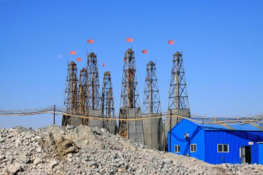 Sondaj kulesi ve metal evler mavi gökyüzünün altında