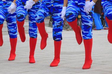 Mavi kamuflaj pantolonu ve kırmızı botlar, fotoğrafa yakın çekim.