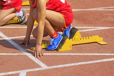Sarı başlangıç bloğu ve sporcular, fotoğrafa yakın çekim