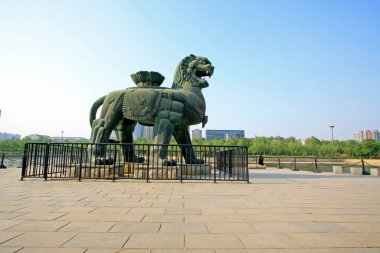 Bir su parkında demir aslan heykeli, fotoğrafa yakın.