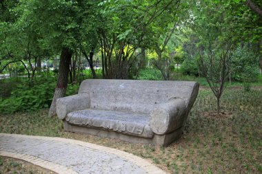 Parktaki kanepe taşı heykeli, fotoğrafa yakın çekim.