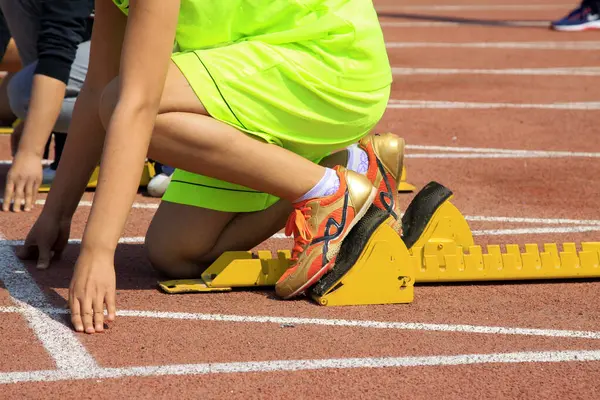 Sarı başlangıç bloğu ve sporcular, fotoğrafa yakın çekim