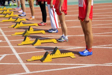 Sarı başlangıç bloğu ve sporcular, fotoğrafa yakın çekim